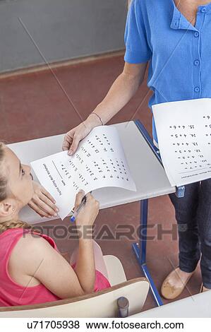 Stock Photo - Teacher giving the exam. Fotosearch