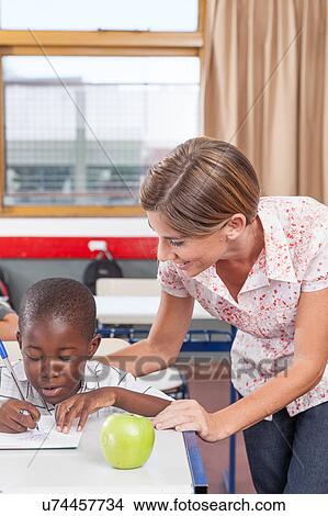 Picture - Teacher helping a boy. Fotosearch