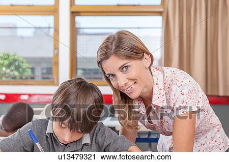 Teacher helping a boy View Large Photo Image Stock Image - Teacher helping a boy. Fotosearch