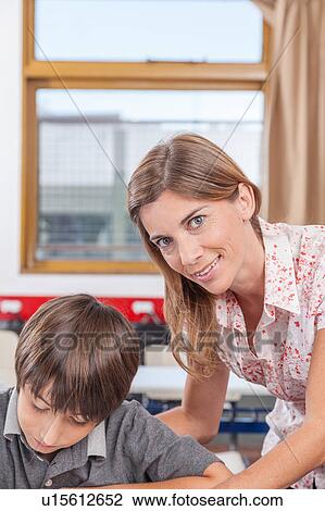 Teacher helping a boy View Large Photo Image Stock Image - Teacher helping a boy. Fotosearch