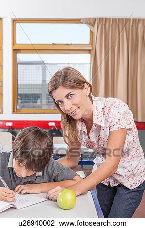 Stock Image - Teacher helping a boy. Fotosearch