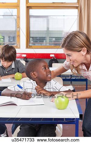 Teacher helping a boy View Large Photo Image Stock Image - Teacher helping a boy. Fotosearch