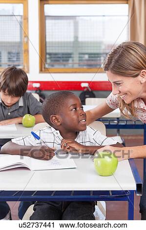 Stock Image - Teacher helping a boy. Fotosearch