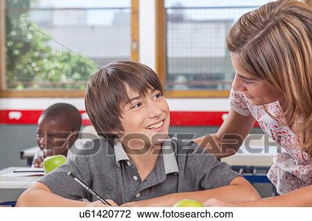Stock Image - Teacher helping a boy. Fotosearch