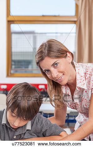 Stock Image - Teacher helping a boy. Fotosearch