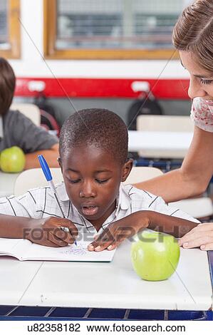 Stock Image - Teacher helping a boy. Fotosearch