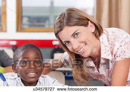 Teacher helping a boy View Large Photo Image Stock Photo - Teacher helping a boy. Fotosearch