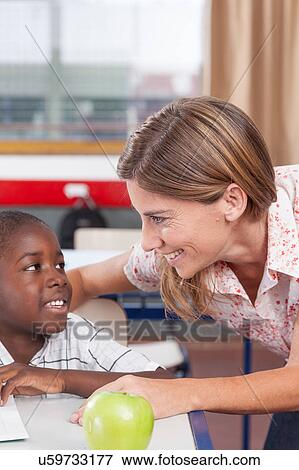Stock Photo - Teacher helping a boy. Fotosearch