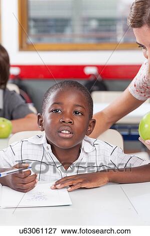 Stock Photo - Teacher helping a boy. Fotosearch