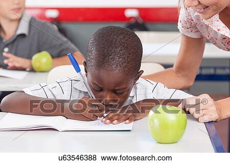 Stock Photo - Teacher helping a boy. Fotosearch