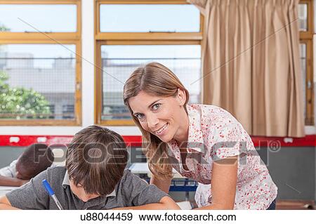 Stock Photo - Teacher helping a boy. Fotosearch