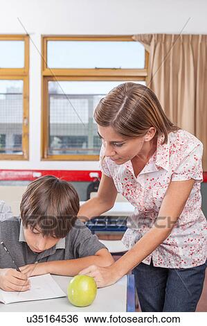 Stock Photograph - Teacher helping a boy. Fotosearch