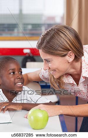 Stock Photography - Teacher helping a boy. Fotosearch