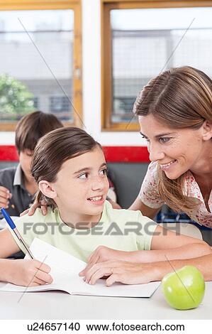 teacher helping a girl in the classroom View Large Photo Image Stock Image - teacher helping a girl in the classroom. Fotosearch