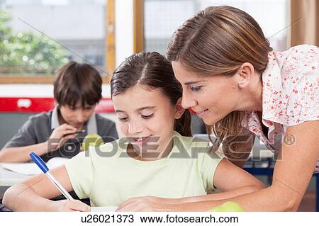 teacher helping a girl in the classroom View Large Photo Image Stock Image - teacher helping a girl in the classroom. Fotosearch