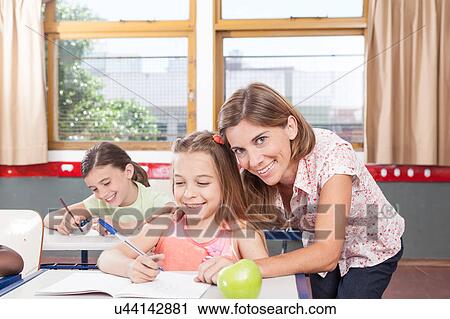 teacher helping a girl in the classroom View Large Photo Image Stock Image - teacher helping a girl in the classroom. Fotosearch