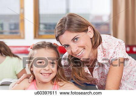 teacher helping a girl in the classroom View Large Photo Image Stock Image - teacher helping a girl in the classroom. Fotosearch