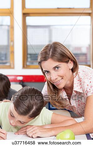 teacher helping a girl in the classroom View Large Photo Image Stock Photo - teacher helping a girl in the classroom. Fotosearch