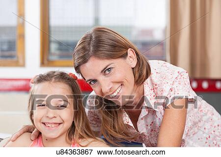 teacher helping a girl in the classroom View Large Photo Image Stock Photo - teacher helping a girl in the classroom. Fotosearch