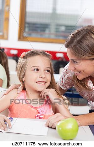 teacher helping a girl in the classroom View Large Photo Image Stock Photography - teacher helping a girl in the classroom. Fotosearch