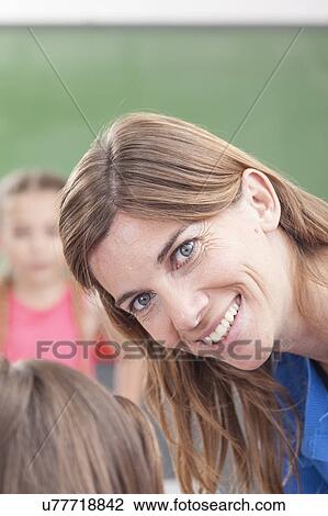 Teacher looking at camera and smiling View Large Photo Image Stock Image - Teacher looking at camera and smiling. Fotosearch