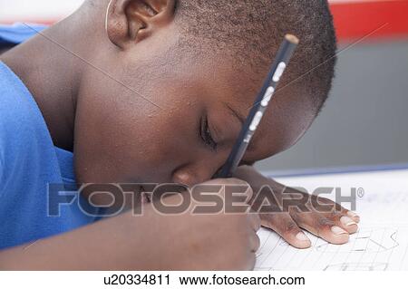 The boy writing in his notebook View Large Photo Image Stock Image - The boy writing in his notebook. Fotosearch