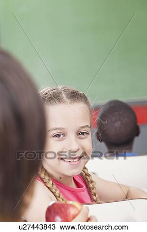 Stock Image - The girl giving an apple. Fotosearch