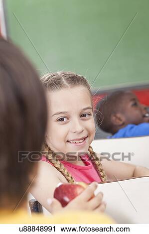 Stock Image - The girl giving an apple. Fotosearch