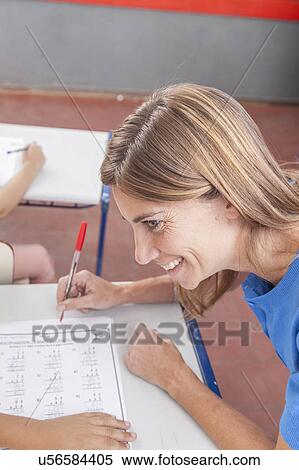the teacher checking the homework and looking at pupil View Large Photo Image Stock Photography - the teacher checking the homework and looking at pupil. Fotosearch
