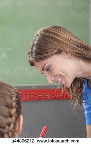 Stock Image - The teacher checking the homework. Fotosearch