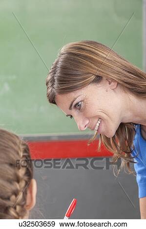 Stock Photo - The teacher checking the homework. Fotosearch