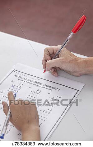 Stock Photo - The teacher checking the homework. Fotosearch