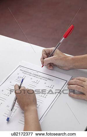 Stock Photo - The teacher checking the homework. Fotosearch
