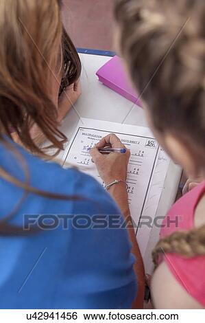 Stock Photograph - The teacher checking the homework. Fotosearch