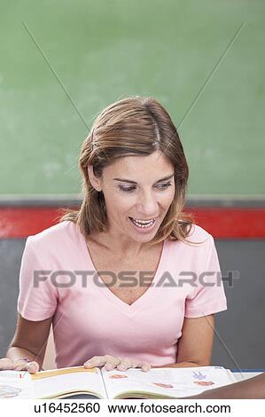 Stock Image - The teacher reading a book. Fotosearch