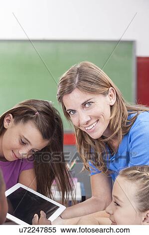 the teacher showing something and looking at camera View Large Photo Image Stock Photography - the teacher showing something and looking at camera. Fotosearch