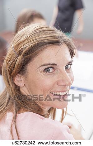 The teacher smiling and looking at camera View Large Photo Image Stock Image - The teacher smiling and looking at camera. Fotosearch