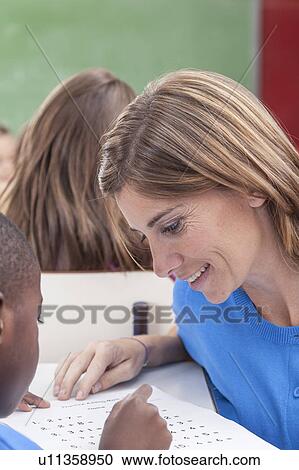 Stock Image - The teacher teaching to pupil. Fotosearch
