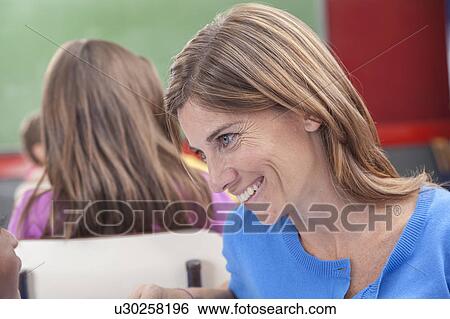 Stock Photograph - The teacher teaching to pupil. Fotosearch