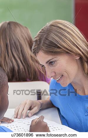 Stock Photograph - The teacher teaching to pupil. Fotosearch