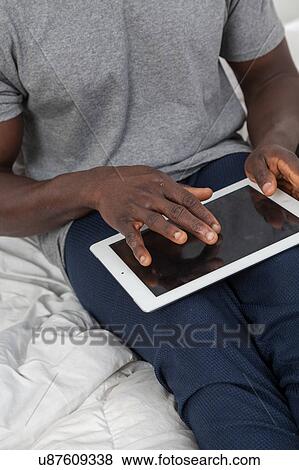 Touching the screen of his tablet View Large Photo Image Stock Photo - Touching the screen of his tablet. Fotosearch