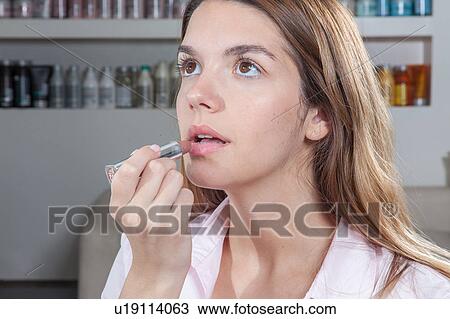 Woman applying her lipstick View Large Photo Image Stock Image - Woman applying her lipstick. Fotosearch