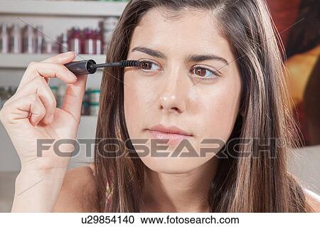 Woman applying mascara on her eyes View Large Photo Image Stock Image - Woman applying mascara on her eyes. Fotosearch