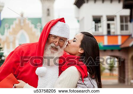 Woman giving a kiss to santa claus View Large Photo Image Stock Photography - Woman giving a kiss to santa claus. Fotosearch