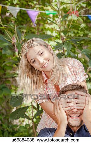Stock Photo - Woman giving to her boyfriend a surprise. Fotosearch