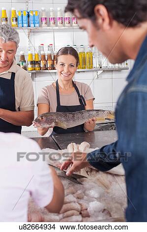 Picture - Woman holding a white salmon. Fotosearch
