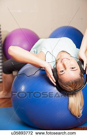 Stock Image - Woman listen to music in yoga class. Fotosearch