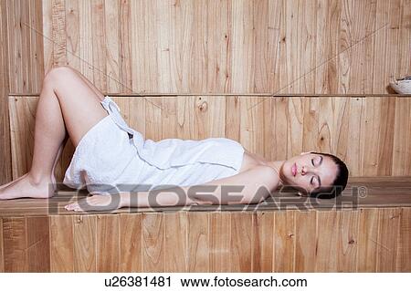 Woman lying down inside the sauna View Large Photo Image Stock Image - Woman lying down inside the sauna. Fotosearch