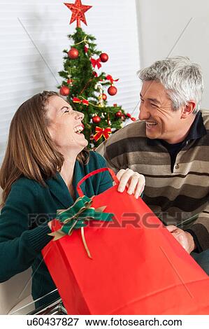 Woman opening the gift and laughing View Large Photo Image Stock Photo - Woman opening the gift and laughing. Fotosearch