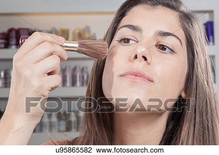 Woman putting blush on her cheeks View Large Photo Image Stock Image - Woman putting blush on her cheeks. Fotosearch